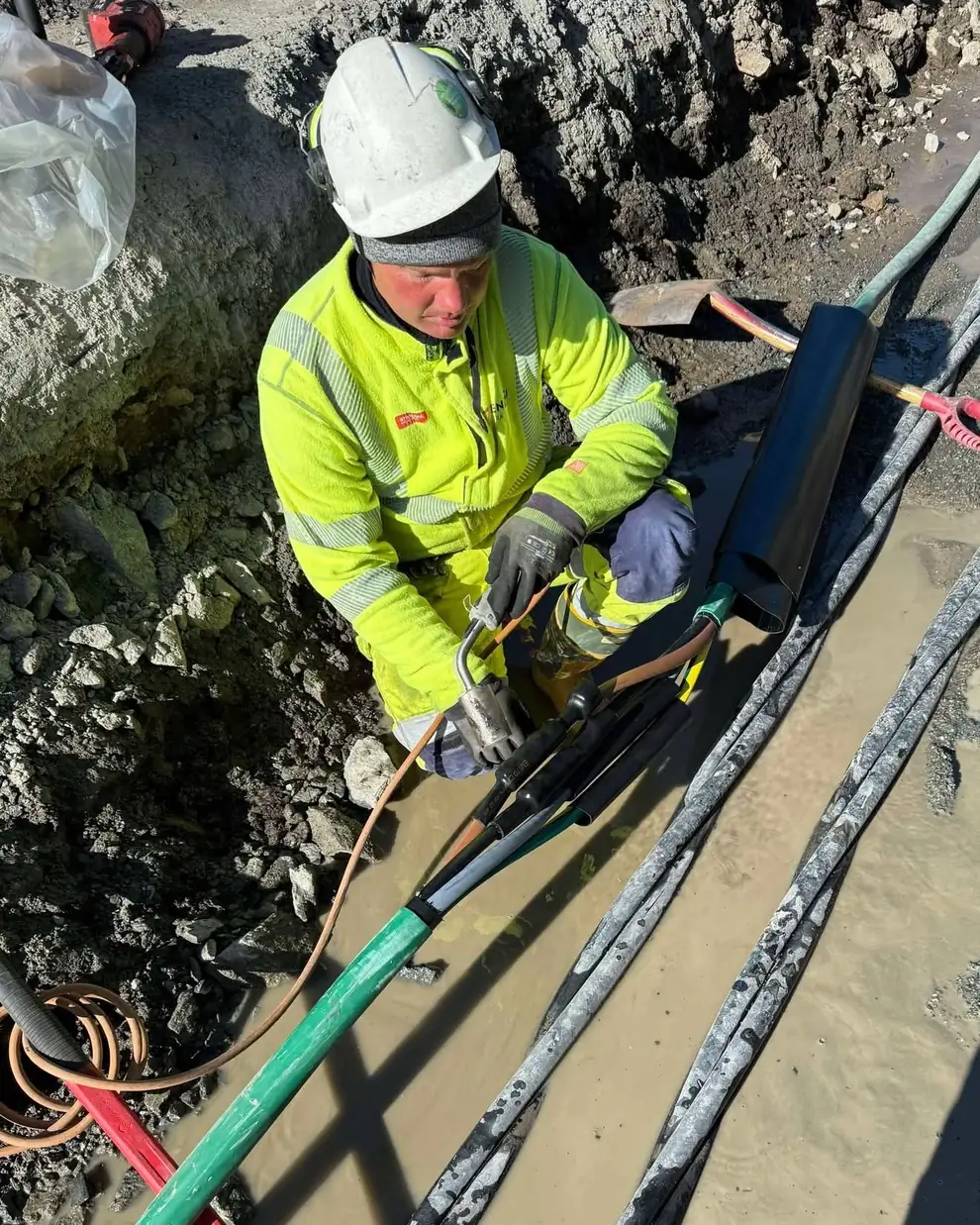 Montør skjøter kabel nede i en grøft